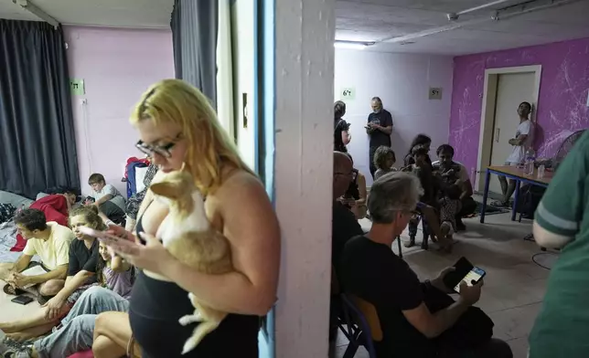 Israelis gather in a public bomb shelter during a missile alert from Iran, in Haifa, Israel,Thursday, June 19, 2025. (AP Photo/Baz Ratner)