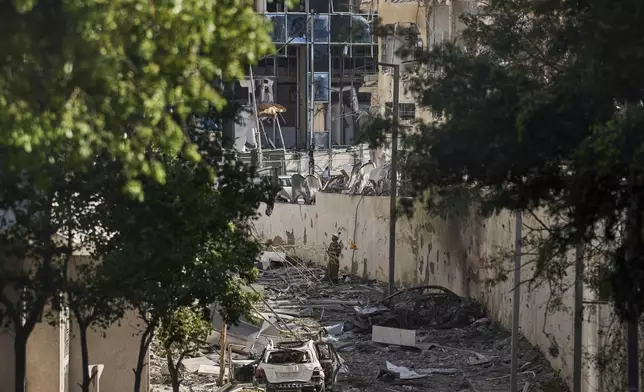 A member of the Israeli security forces checks a damaged area a day after it was hit by an Iranian missile strike in Ramat Gan, Israel, Friday, June 20, 2025. (AP Photo/Leo Correa)