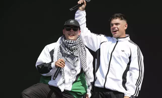 Liam Og, left, and Naoise O Caireallain of the hip hop trio Kneecap perform during the Glastonbury Festival in Worthy Farm, Somerset, England, Saturday, June 28, 2025. (Scott A Garfitt/Invision/AP)