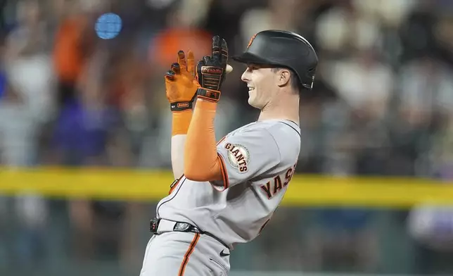 San Francisco Giants' Mike Yastrzemski gestures to the dugout after he reached second base on an double that drove in two runs off Colorado Rockies relief pitcher Tyler Kinley in the eighth inning of a baseball game Wednesday, June 11, 2025, in Denver. (AP Photo/David Zalubowski)