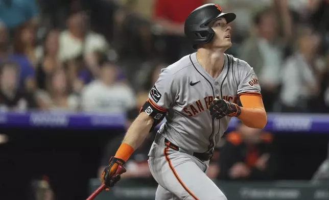 San Francisco Giants' Mike Yastrzemski follows the flight of his double to drive in two runs off Colorado Rockies relief pitcher Tyler Kinley in the eighth inning of a baseball game Wednesday, June 11, 2025, in Denver. (AP Photo/David Zalubowski)