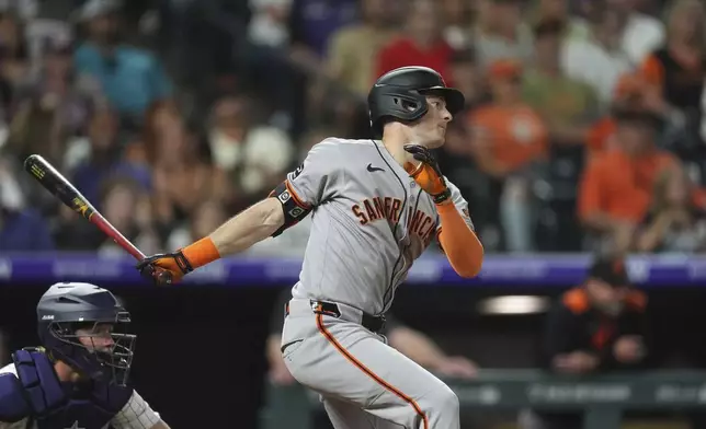 San Francisco Giants' Mike Yastrzemski follows the flight of his RBI single off Colorado Rockies relief pitcher Ryan Rolison in the ninth inning of a baseball game Wednesday, June 11, 2025, in Denver. (AP Photo/David Zalubowski)