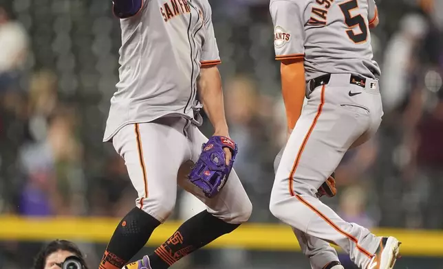 San Francisco Giants shortstop Willy Adames, left, and right fielder Mike Yastrzemski celebrate after defeating the Colorado Rockies in a baseball game Wednesday, June 11, 2025, in Denver. (AP Photo/David Zalubowski)