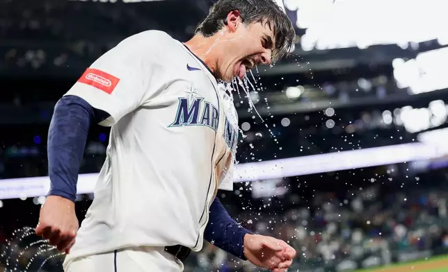 Seattle Mariners' Cole Young reacts after being dunked with water by J.P. Crawford after reaching first on a fielder's choice that allowed Miles Mastrobuoni to score the walk-off run during the 11th inning of a baseball game against the Minnesota Twins Saturday, May 31, 2025, in Seattle. (AP Photo/Ryan Sun)