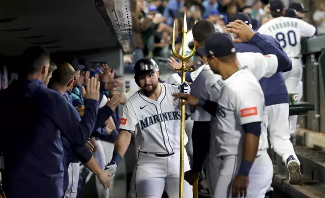 Seattle Mariners designated hitter Cal Raleigh, center, celebrates in the dugout after hitting a two-run home run during the third inning of a baseball game against the Minnesota Twins, Saturday, May 31, 2025, in Seattle. (AP Photo/Ryan Sun)