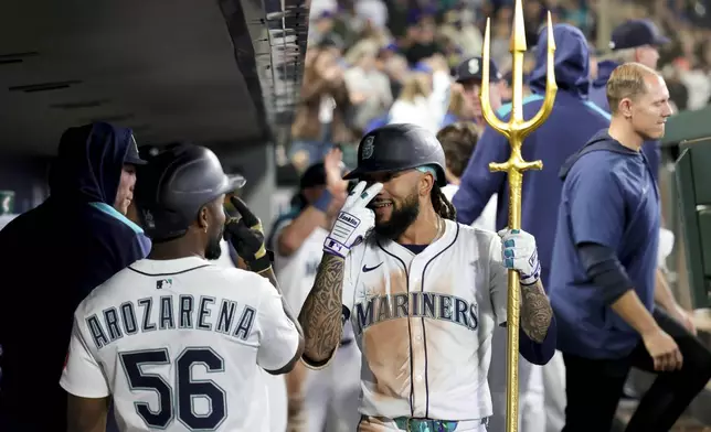 Seattle Mariners' J.P. Crawford, center, celebrates in the dugout with left fielder Randy Arozarena after hitting a go-ahead two-run home run during the seventh inning of a baseball game against the Minnesota Twins Saturday, May 31, 2025, in Seattle. (AP Photo/Ryan Sun)