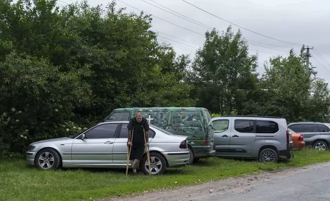 A former Ukrainian soldier with an amputated limb participates the funeral ceremony for his comrade Dmytro Shapovalov in Yosypivka village, Vinnytsia region, Ukraine, on Friday, June 13, 2025. (AP Photo/Evgeniy Maloletka)