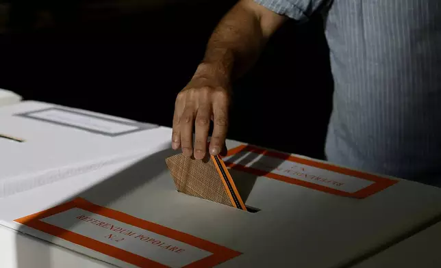 A man casts his ballot on referendums on citizenship and job protections, at a polling station in Rome, Sunday, June 8, 2025. (Cecilia Fabiano/LaPresse via AP)