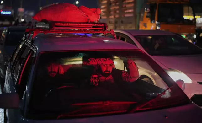 People return home after shopping the day before Eid al-Adha in Kabul, Afghanistan, Friday, June 6, 2025. (AP Photo/Ebrahim Noroozi)