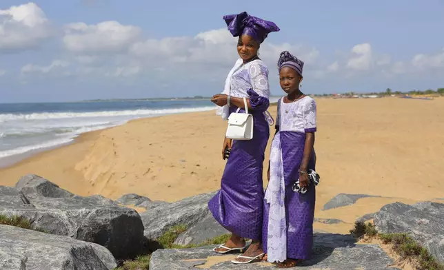 A mother and daughter pose for a photo at a beach after Eid al-Adha prayers in Keta, Ghana, Friday, Jun 6, 2025. (AP Photo/Misper Apawu)