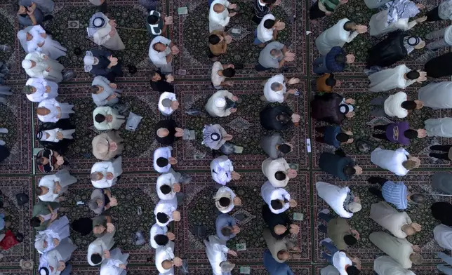 Iraqi Shiite Muslims gather for an Eid al-Adha prayer at the shrine of Imam Ali shrine in Najaf, Iraq, Saturday, June 7, 2025. (AP Photo/Anmar Khalil)