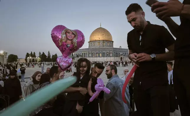 Muslim children receive balloons as they gather for Eid al-Adha prayers next to the Dome of the Rock shrine at the Al Aqsa Mosque compound in Jerusalem's Old City, Friday, June 6, 2025. (AP Photo/Mahmoud Illean)