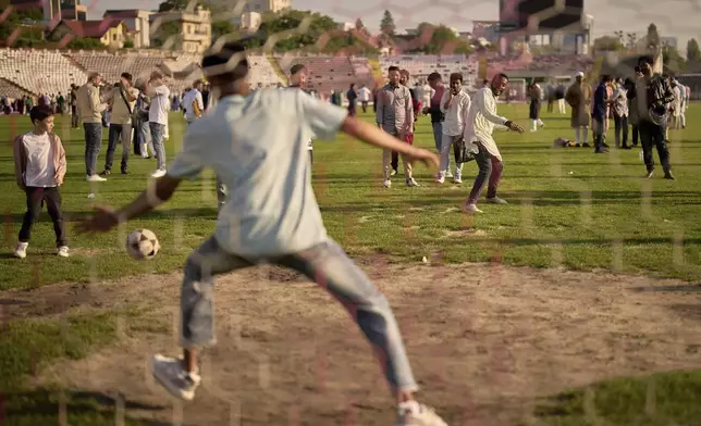 Muslim men take penalty shots on the soccer pitch at Dinamo stadium after attending Eid al-Adha prayers in Bucharest, Romania, Friday, June 6, 2025. (AP Photo/Vadim Ghirda)