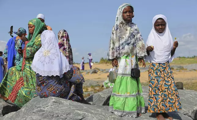 People stand on a beach after Eid al-Adha prayers in Keta, Ghana, Friday, Jun 6, 2025 (AP Photo/Misper Apawu)