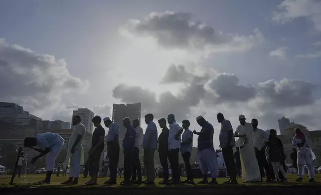 Devotees queue up near a water tap before praying as they mark the Muslim festival of Eid al-Adha in Colombo, Sri Lanka, Saturday, June 7, 2025. (AP Photo/Eranga Jayawardena)