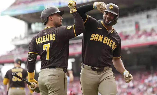 San Diego Padres' Xander Bogaerts, right, is congratulated by Jose Iglesias after hitting a solo home run in the fourth inning of a baseball game against the Cincinnati Reds, Sunday, June 29, 2025, in Cincinnati. (AP Photo/Kareem Elgazzar)