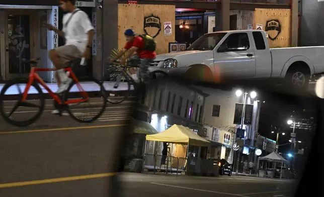 Bicycle riders cruise past boarded up businesses along 1st St. in Little Tokyo Tuesday, June 17, 2025, in Los Angeles. (AP Photo/Wally Skalij)