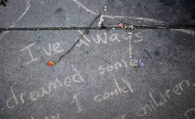 A wilted rose lays on a sidewalk outside the downtown Metropolitan Detention Center Tuesday, June 17, 2025, in Los Angeles. (AP Photo/Wally Skalij)