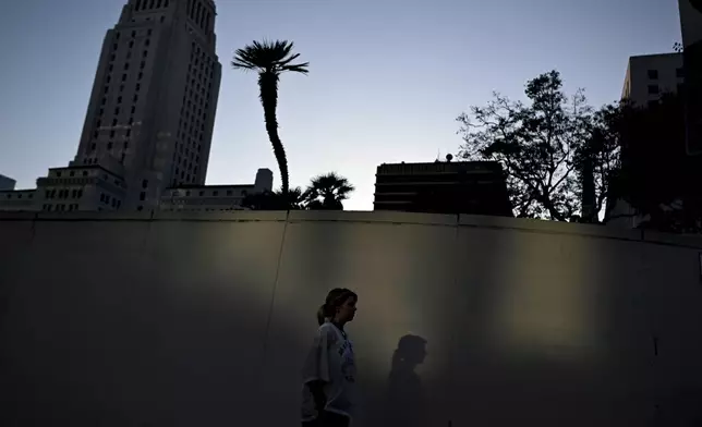 A woman walks in the quiet streets of downtown across the from the Robert Young federal building Tuesday, June 17, 2025, in Los Angeles. (AP Photo/Wally Skalij)
