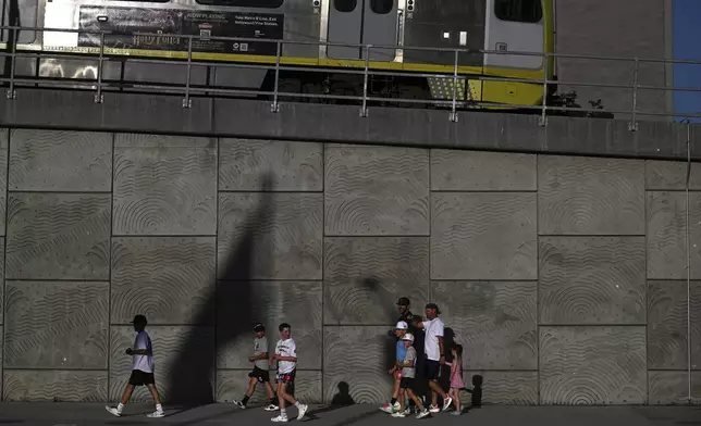 A group of pedestrians walk across the street from the downtown Metropolitan Detention Center Tuesday, June 17, 2025, in Los Angeles. (AP Photo/Wally Skalij)
