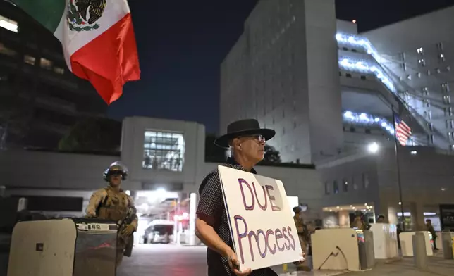 A protester stands outside the Metropolitan Detention Center Tuesday, June 17, 2025, in Los Angeles. (AP Photo/Wally Skalij)