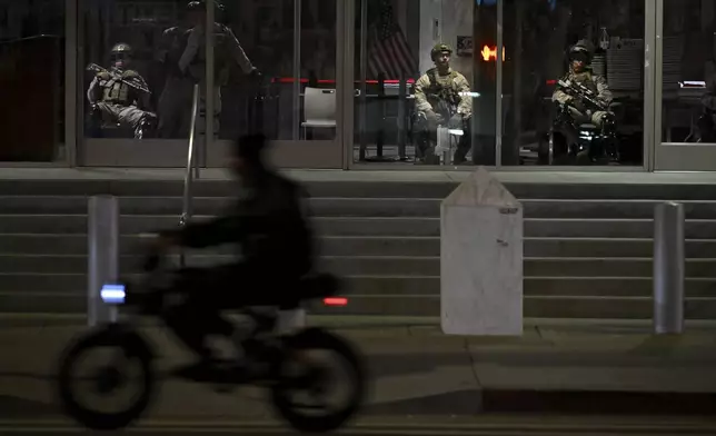 U.S. Marines sit in the lobby while guarding the Robert Young Federal Building Tuesday, June 17, 2025, in Los Angeles. (AP Photo/Wally Skalij)
