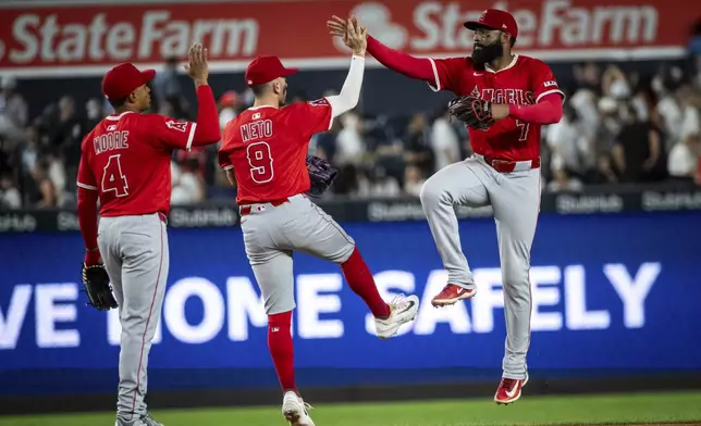 Los Angeles Angels outfielder Jo Adell (7) and shortstop Zach Neto (9) congratulate each other after the team's win against the New York Yankees following a baseball game, Wednesday, June 18, 2025, in New York. (AP Photo/Angelina Katsanis)