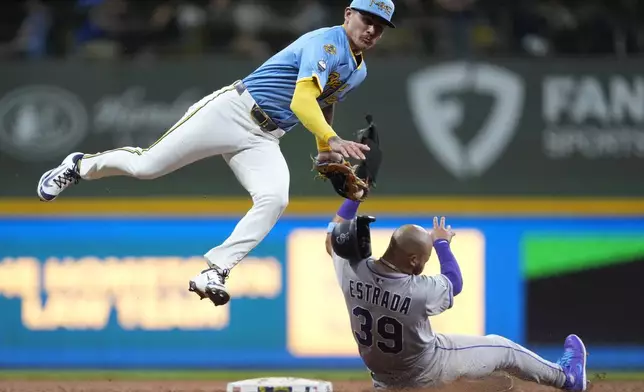Milwaukee Brewers' Joey Ortiz, top, tags out Colorado Rockies' Thairo Estrada (39) at second base on a stolen base-attempt during the seventh inning of a baseball game Friday, June 27, 2025, in Milwaukee. (AP Photo/Aaron Gash)
