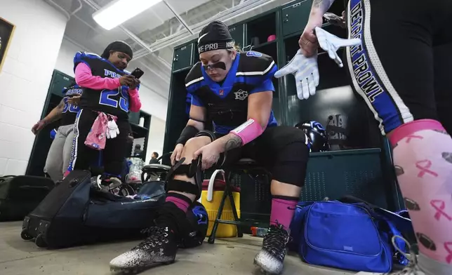 Detroit Prowl's Lexi Bryant adjusts her knee brace before an AWFL women's football game against the Lansing Legacy in Allen Park, Mich., Saturday, May 10, 2025. (AP Photo/Paul Sancya)
