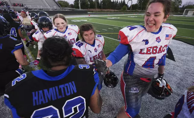 Detroit Prowl's Jasmine Hamilton (32) reacts with Lansing Legacy's Hana Walter (44) in a post-game line after an AWFL women's football game in Allen Park, Mich., Saturday, May 10, 2025. (AP Photo/Paul Sancya)