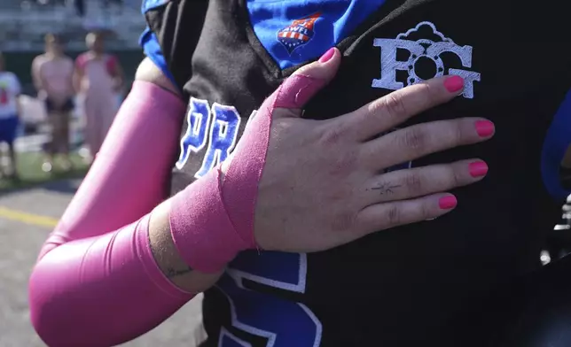 Detroit Prowl's Sydney Hebel holds her hand over her heart during the playing of the national anthem at the start of the AWFL women's football game against the Lansing Legacy, in Allen Park, Mich., Saturday, May 10, 2025. (AP Photo/Paul Sancya)