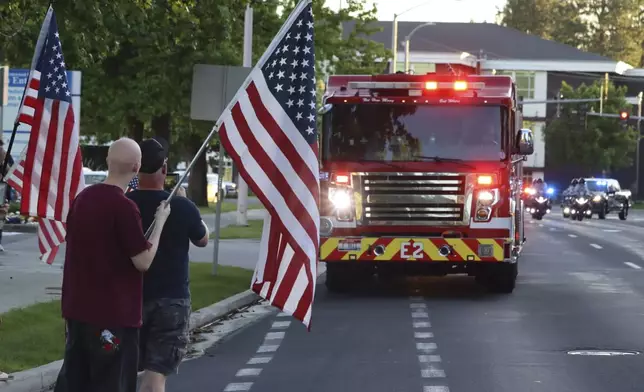 A procession from Kootenai Health headed to Spokane after a few firefighters were killed Sunday, June 29, 2025, when they were ambushed by sniper fire while responding to a blaze in a northern Idaho mountain community, in Coeur d’Alene, Idaho. (Bill Buley/Coeur D'Alene Press via AP)