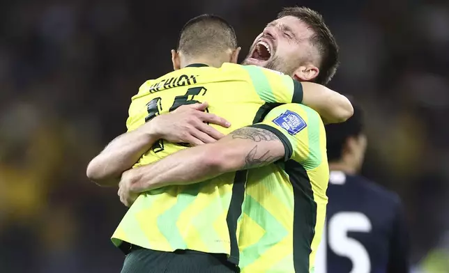 Australia's Cameron Burgess, right, and Aziz Behich celebrate after defeating Japan in their World Cup 2026 group C qualifying soccer match in Perth, Thursday, June 5, 2025. (AP Photo/Trevor Collens)