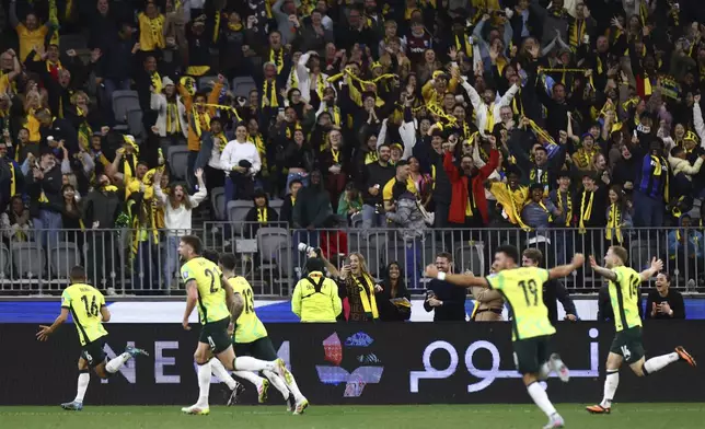 Australia's Aziz Behich, left, celebrates after scoring against Japan during their World Cup 2026 group C qualifying soccer match in Perth, Thursday, June 5, 2025. (AP Photo/Trevor Collens)