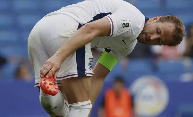 England's Harry Kane cleans shoe during a World Cup 2026 group K qualifying soccer match between Andorra and England at the RCDE Stadium in Barcelona, Spain, Saturday, June 7, 2025. (AP Photo/Joan Monfort)