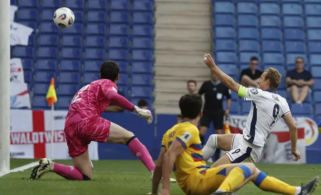 England's Harry Kane, right, scores the opening goal during a World Cup 2026 group K qualifying soccer match between Andorra and England at the RCDE Stadium in Barcelona, Spain, Saturday, June 7, 2025. (AP Photo/Joan Monfort)