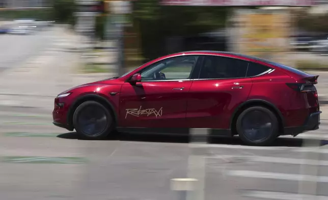 A driverless Tesla robotaxi, a ride-booking service, moves through traffic, Sunday, June 22, 2025, in Austin, Texas. (AP Photo/Eric Gay)
