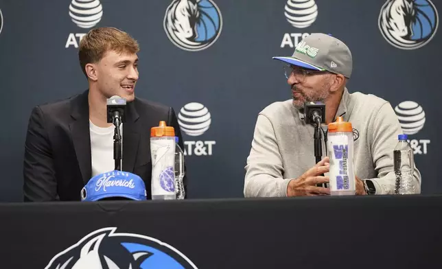 Dallas Mavericks' Cooper Flagg, left, the No. 1 overall pick in the NBA draft, smiles at head coach Jason Kidd, right, as they respond to questions during an NBA basketball press conference at the team's practice facility, Friday, June 27, 2025, in Dallas. (AP Photo/Tony Gutierrez)