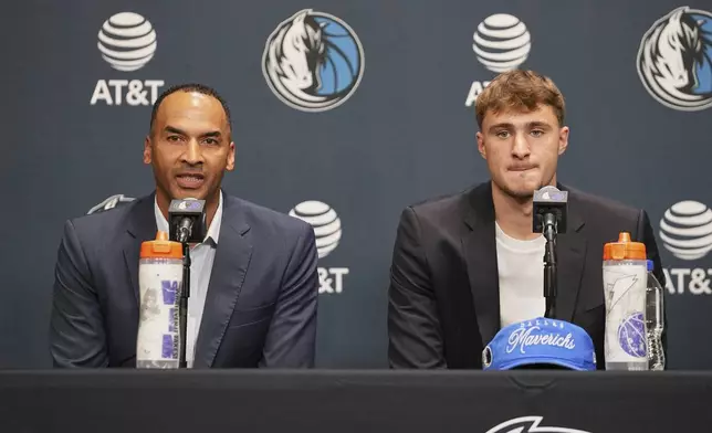 Dallas Mavericks President of Basketball Operations and General Manager Nico Harrison, left, responds to a question as the Mavericks' Cooper Flagg, right, the No. 1 overall pick in the NBA draft, looks on during an NBA basketball press conference at the team's practice facility, Friday, June 27, 2025, in Dallas. (AP Photo/Tony Gutierrez)