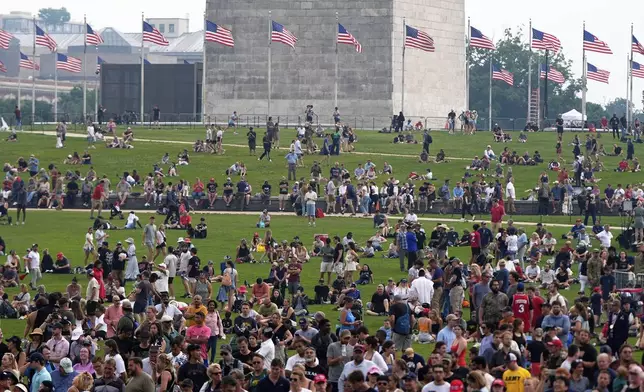 People on the lawn around the Washington Monument as President Donald Trump attends a military parade commemorating the Army's 250th anniversary, coinciding with his 79th birthday, Saturday, June 14, 2025, in Washington. (AP Photo/Julia Demaree Nikhinson)