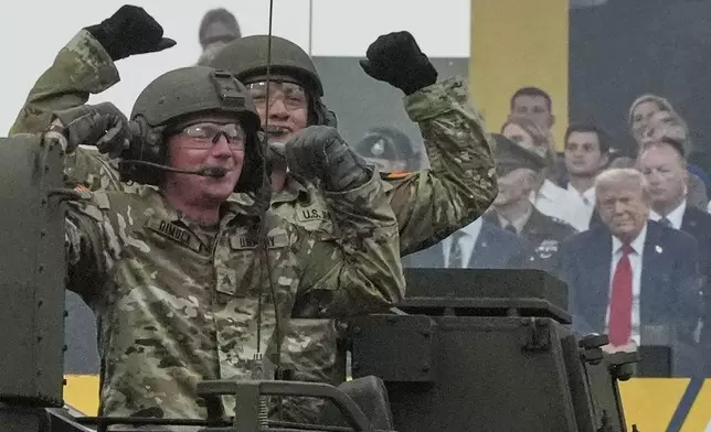 Army soldiers cheer as President Donald Trump watches as he attends a military parade commemorating the Army's 250th anniversary, coinciding with his 79th birthday, Saturday, June 14, 2025, in Washington. (AP Photo/Julia Demaree Nikhinson)