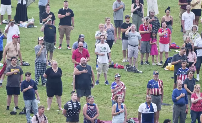People attend a military parade commemorating the Army's 250th anniversary and coinciding with President Donald Trump's 79th birthday, Saturday, June 14, 2025, in Washington. (AP Photo/Jacquelyn Martin)