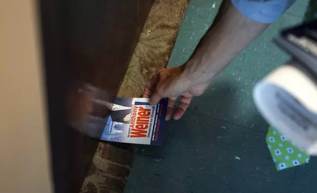 Anthony Weiner slides a campaign flyer under a resident's door while campaigning for a seat on the New York City Council, Thursday, May 29, 2025 in New York. (AP Photo/Angelina Katsanis)