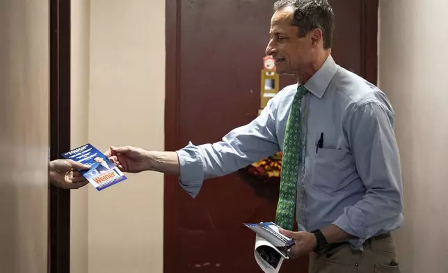 Anthony Weiner hands a resident his campaign flyer while talking about his bid for New York City Council, Thursday, May 29, 2025 in New York. (AP Photo/Angelina Katsanis)