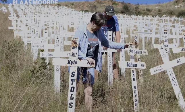 Anita de Lange, left, and her son, Hansie de Lange, tidy up at the Witkruis Monument, near Polokwane, South Africa, May 24, 2025. (AP Photo/Mogomotsi Magome)