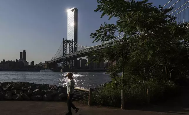 Pedestrians walk along Brooklyn Bridge Park as an air quality alert was issued for the New York region due to wildfire smoke from Canada, Wednesday, June 4, 2025, in New York. (AP Photo/Heather Khalifa)