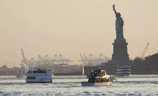 The Statue of Liberty is seen while the sun sets in the Brooklyn borough of New York, Wednesday, June 4, 2025, during an air quality alert issued for the New York region due to wildfire smoke from Canada. (AP Photo/Heather Khalifa)