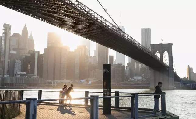 People look out at the New York City skyline underneath the Brooklyn Bridge as an air quality alert was issued for the New York region due to wildfire smoke from Canada, Wednesday, June 4, 2025, in New York. (AP Photo/Heather Khalifa)