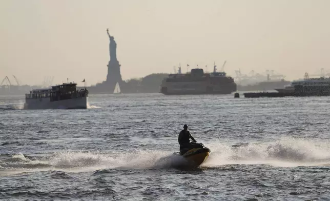 An air quality alert has been issued for the New York region due to wildfire smoke from Canada as a person rides a jet ski in the East River, Wednesday, June 4, 2025, in New York. (AP Photo/Heather Khalifa)