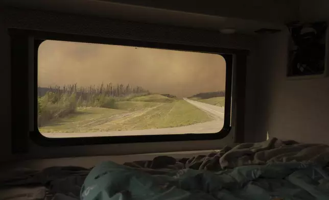 Wildfire smoke hangs in the air above Highway 97 north of Buckinghorse River, British Columbia, on Friday, May 30, 2025. (Nasuna Stuart-Ulin/The Canadian Press via AP)